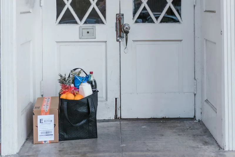 A plain unbranded cardboard parcel resting on a doorstep, with no external indication of its contents