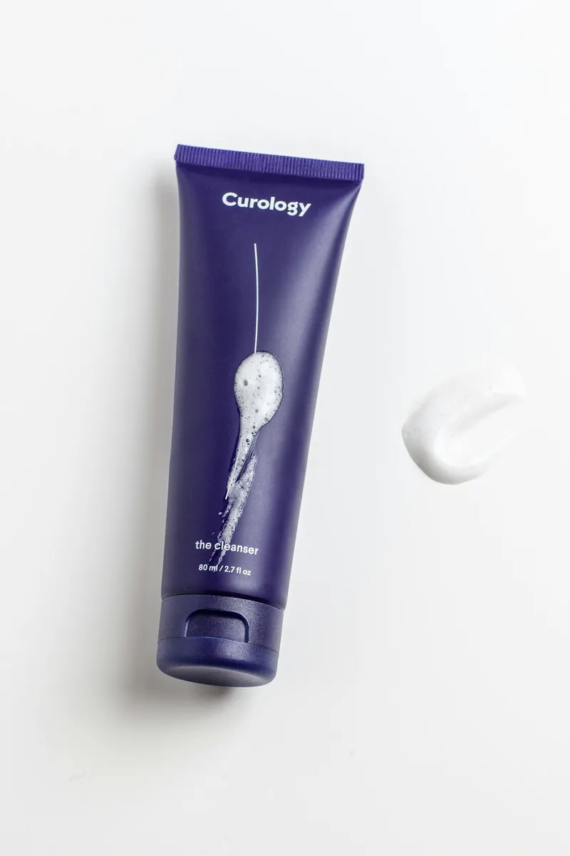 Minimal arrangement of plain cosmetic pump bottles on a clean light surface, suggesting personal care and hydration