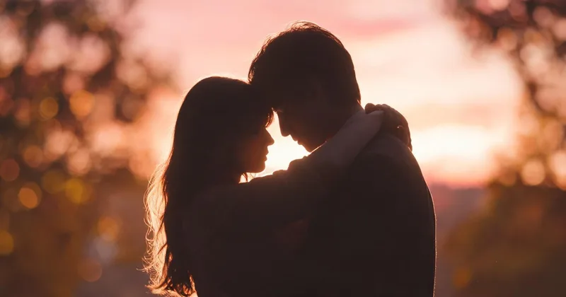 Silhouette of a couple in warm, low light sharing an intimate, unhurried moment together