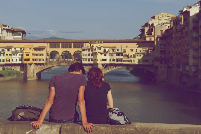 A couple sitting close together in a quiet evening scene, reflecting the partnered, private context most rings and sleeves are bought for