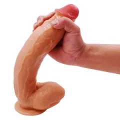 Close-up of a hand compressing the flexible glans and shaft of the silicone dildo
