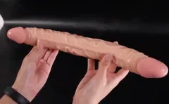 Both veined ends of the silicone double dildo held up side by side in two hands