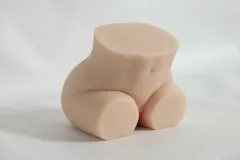 Angled view of the realistic silicone sex doll seated, showing belly button and abdomen