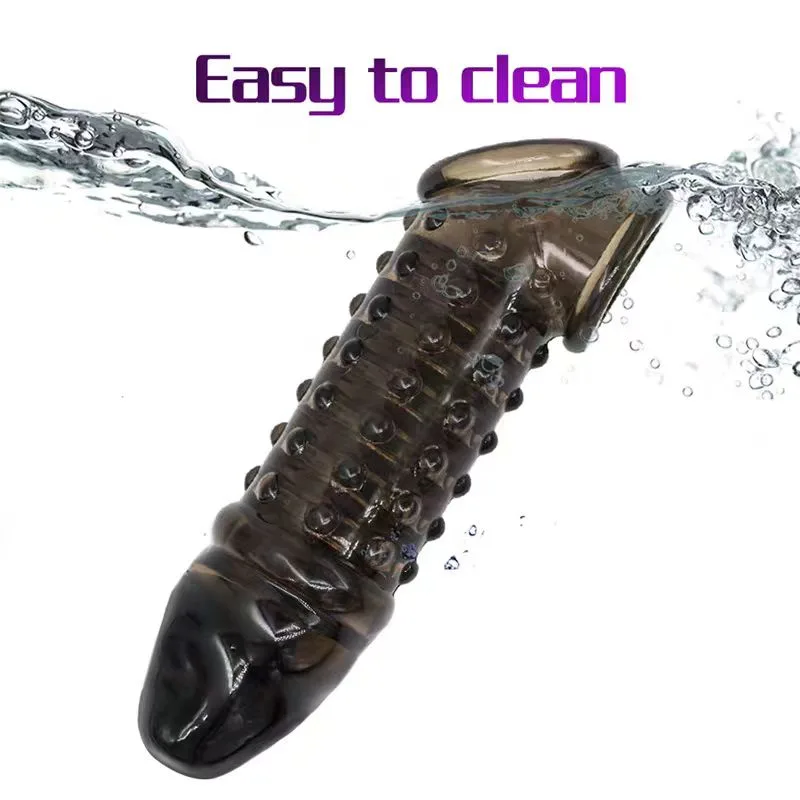 Transparent black spiked penis sleeve held under running water for cleaning