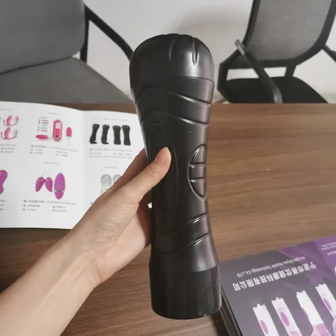 Vibrating masturbator cup in black flashlight-style body with soft TPE sleeve