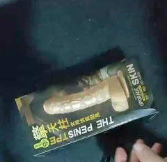 Wearable strap-on dildo set in its retail box with the skin-tone dildo and black harness visible